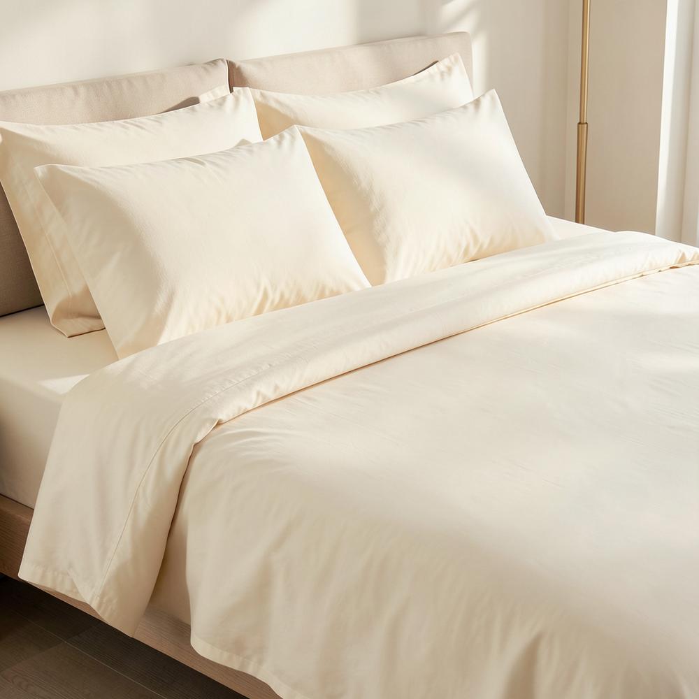 Ivory percale bed sheet set on a neatly made bed